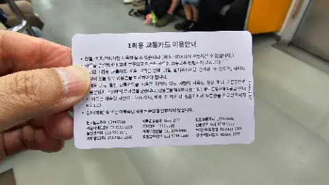 A person is holding a card with foreign writing on
