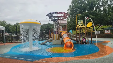 A playground with a slide and a water play area