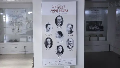 A poster of six people is displayed on a wall