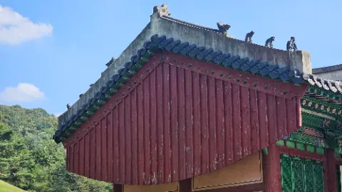 A red and green roofed building with a blue tile