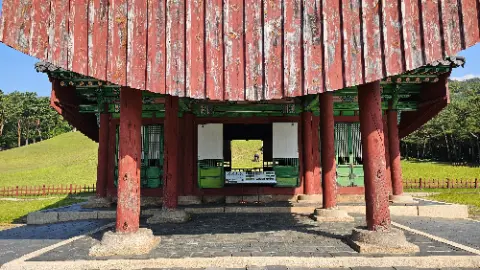 A red building with a white roof and a green