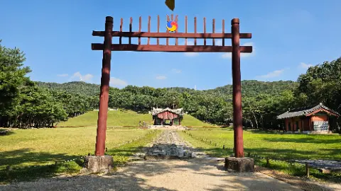 A red wooden archway with a blue and white sign