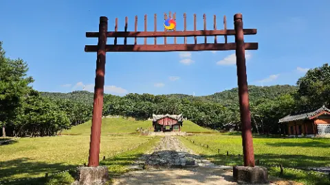 A red wooden archway with a yellow teddy bear on