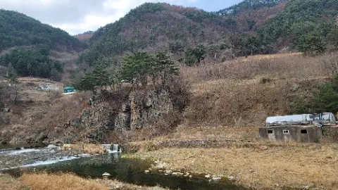 A river with a waterfall and a mountain in the