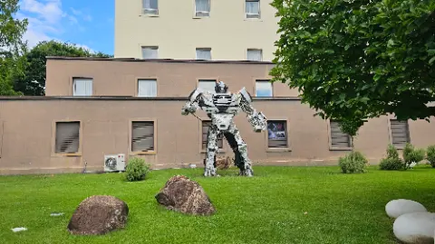 A robot statue is in front of a building