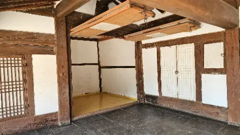 A room with a wooden door and a white wall