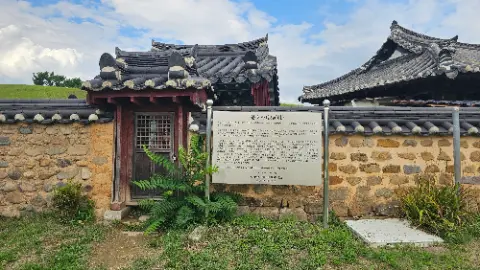 A sign in front of a building with a roof