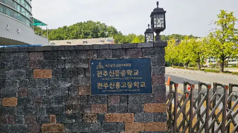 A sign in front of a school building