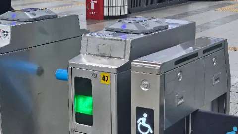 A silver and black subway machine with a green light