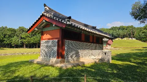 A small brick building with a red roof