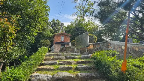 A small brick building with a sign in front of