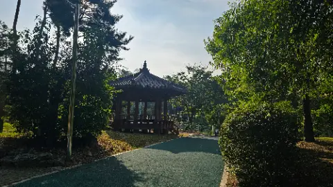 A small pavilion with a roof in a park