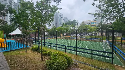 A soccer field with a fence and a tree in