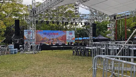 A stage with a large screen and a sign that