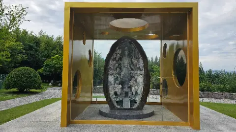 A statue of a person is inside a gold building