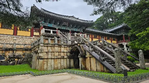 A stone building with a staircase leading to a doorway