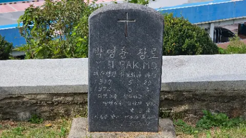 A stone monument with a cross on top and the