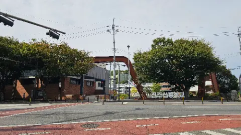 A street with a red crosswalk and a bridge over
