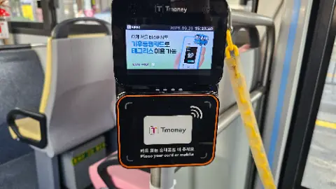 A T-money card reader with a cell phone inserted