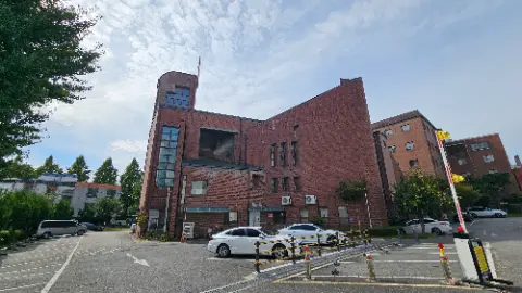 A white car is parked in front of a brick