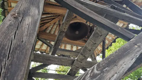 A wooden structure with a bell in the center