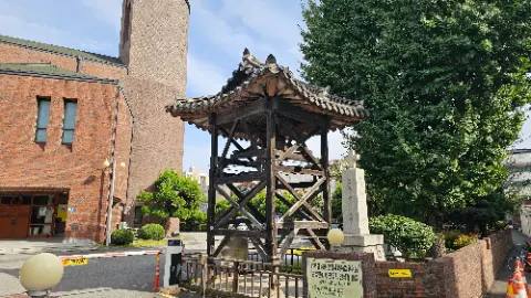 A wooden structure with a roof and a sign in