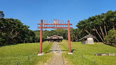 A wooden structure with a roof and a small building