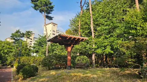 A wooden structure with a roof in a park