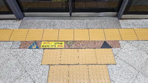 A yellow and black tile floor with a sign in