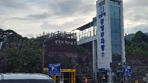 A yellow building with a blue sign and a parking