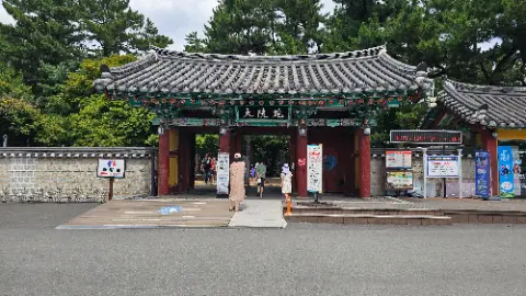 People walking through a gate in front of a building