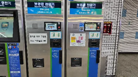 Two silver coin machines with a blue and white sign